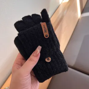 Detailed view of black knit half finger gloves with chic brown tag and warm winter design texture.