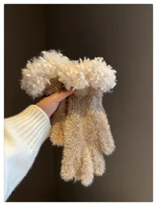 Close up view of cozy winter gloves featuring plush white cuffs and soft knitted texture.
