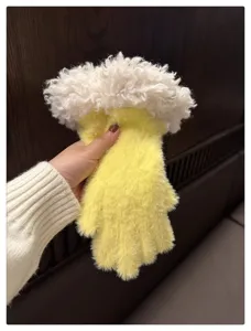 Detailed view of yellow plush winter gloves with fluffy white sherpa cuffs for cold weather.