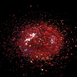 Close-up detail of red laser nail glitter flakes and hexagonal sequins for stunning nail art.
