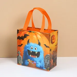 Detail view of cute Halloween monster non-woven candy gift bag with dual orange handles.