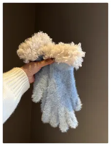 Close-up detail of fluffy blue winter gloves with cozy white faux shearling cuffs for warmth.