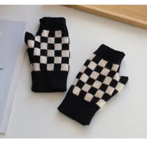Detailansicht von schwarz-weißen Karomuster Strick-Fingerlosen Handschuhen, gemütlich.