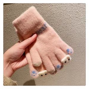 Close-up detail of cute pink winter touchscreen woolen gloves featuring adorable bear paw design.