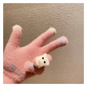 Close-up detail of winter women cute knit gloves with touch screen fingertips and plush bear.