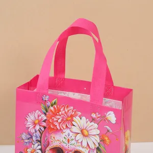 Close-up of pink non-woven gift bag featuring vibrant sugar skull and floral print details.