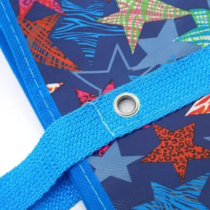 Detailed view of blue non-woven storage bag with colorful star pattern and grommet handle
