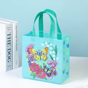 Blue non-woven gift bag with vibrant butterfly and floral print, stylish tote for shopping.