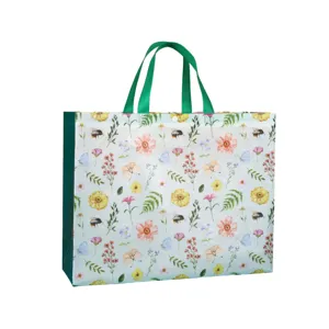 Vista detallada de la bolsa de compras reutilizable con estampado floral y asas verdes.