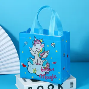 Detailed view of blue non-woven gift bag featuring cute cartoon unicorn and sturdy handles.