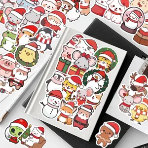 Nahaufnahme süßer Weihnachts-Tieraufkleber auf Notizbuch für DIY-Laptopdekoration.