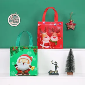 Detail view of Christmas non-woven gift bags with Santa and reindeer prints on display shelf.