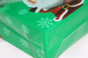 Close-up detail of green Christmas nonwoven gift bag featuring festive snowflake pattern print.