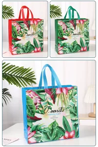 Detailed shot of non-woven shopping bag with tropical floral print and sturdy colored handle.