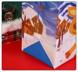 Detail shot of Christmas non-woven gift bag featuring cute cartoon reindeer and snowy winter design.