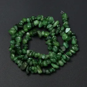 Gros plan de perles en copeaux de cristal vert naturel, forme irrégulière, idéal pour bijoux DIY.