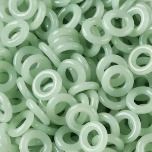 Primer plano de cuentas de vidrio verde claro con estilo jade para bisutería artesanal.