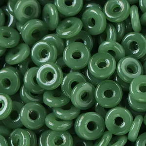 Primer plano cuentas de donut de vidrio imitación jade verde para accesorios de joyería.