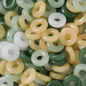 Primer plano de cuentas de anillo de jade de imitacion mixta, ideales para crear joyas artesanales.