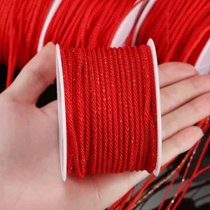 Vue de détail d'un cordon rouge tissé à la main avec fils dorés pour bijoux DIY.