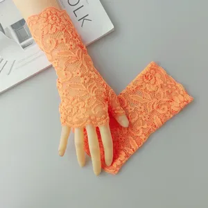 Detailed view of fluorescent orange lace fingerless gloves, showcasing delicate floral hollow-out.