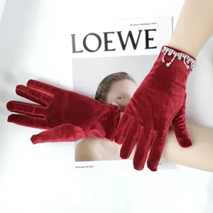 Velvet gloves detail featuring sparkling crystal rhinestone tassels on the elegant red wrist.