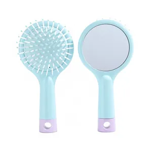 Detailed view of cute round hair brush with mirror and massage cushion in light blue style.