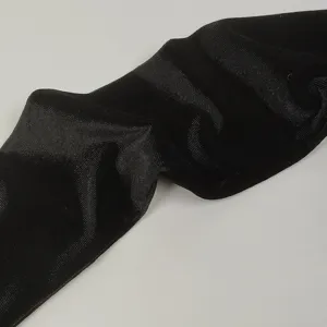 Gros plan détaillé de la texture en tissu velours noir, surface douce, accessoire de soirée élégant.