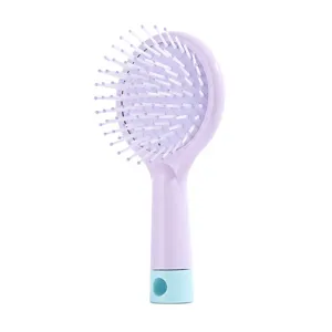 Close-up detail of the portable mini cushion hair brush featuring soft massage pins and hole.