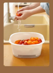 Square plastic draining basket, kitchen vegetable washing basin detail view and use.