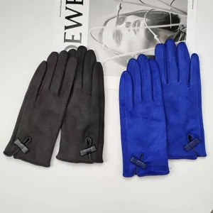 Close-up of winter suede warm gloves with elegant bow detail in black and blue colors.