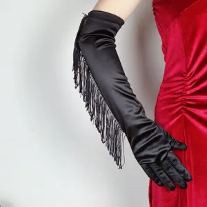 Close-up of elegant black satin long fringe gloves worn with red velvet dress, detail shot.