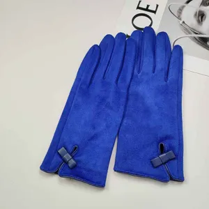 Close-up detail of women winter blue suede gloves featuring elegant bow accent and soft lining.