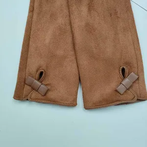 Close up of brown suede winter gloves cuff detail with cute strap decoration, warm apparel.