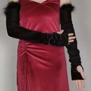 Close-up detail of vintage black velvet long gloves with chic feather trim for evening.