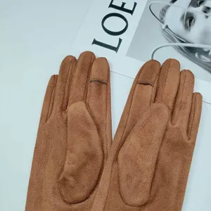 Detailed view of brown winter touch screen gloves suede material warm design texture close-up.