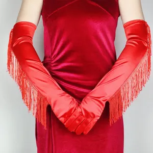 Close-up detail of red satin fringed long gloves, stretchy opera gloves for party.