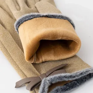 Close-up detail of women winter warm gloves, khaki plush cuff trim and cute leather bow accent.