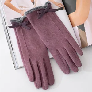 Close-up detail shot of winter women warm gloves featuring plush cuffs and bow decor.