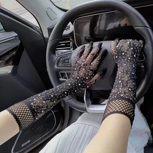 Close-up detail shot of sparkling rhinestone black fishnet gloves worn inside luxury car.