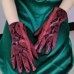 Detailed view of women's red faux suede snake pattern touch screen gloves closeup shot.