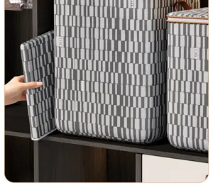 Detailed view of large capacity striped quilt storage bag with sturdy frame on closet shelf.