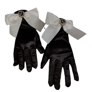 Eleganti guanti in raso nero con un grande fiocco bianco e fibbia in strass scintillante.