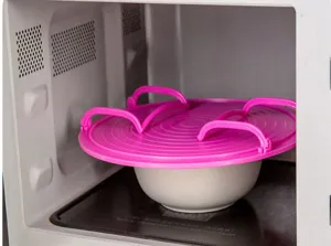 Silicone microwave plate cover with foldable handles, heat-resistant food splatter guard.