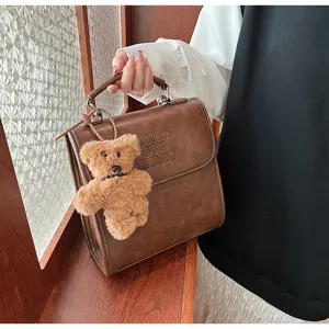 Vintage retro leather casual backpack with cute plush bear pendant and chic letters.