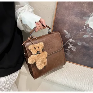 Vintage brown PU leather top-handle handbag with cute teddy bear pendant for women.