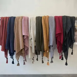 Gedetailleerd overzicht van meerdere effen dames sjaals met elegante kwastjes in diverse kleuren.