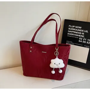 Red vintage tote bag detail view with plush cloud charm and minimalist metal bar decoration.