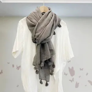 Detailansicht eines einfarbigen Leinenschals mit Quasten, elegant drapiert für den Alltag.