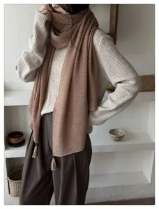 Gedetailleerd overzicht van de gestructureerde effen sjaal met kwastjes voor elegante stijl.